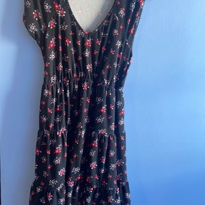 A black knee length dress with red flowers on it